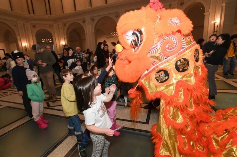 Children playing with a lion dancer