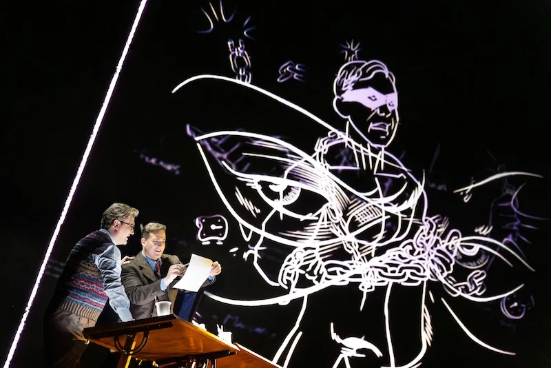 Two people stand below a large illustration of a superhero