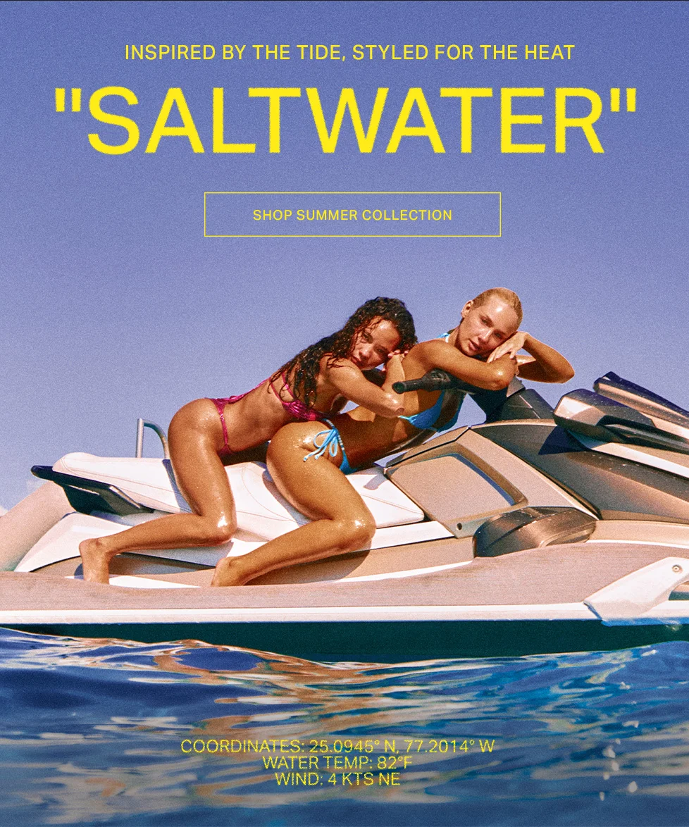 Two models in pink and blue bikinis pose on a jet ski in sparkling blue ocean water under a purple sky. Showcasing the "Saltwater" summer collection.