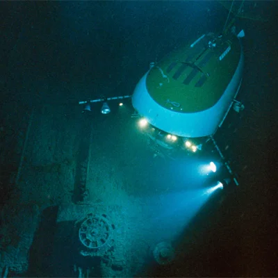 Lights from a Mir submersible, a deep-sea vehicle with room for three people, expose the Titanic’s port anchor winch on the foredeck.