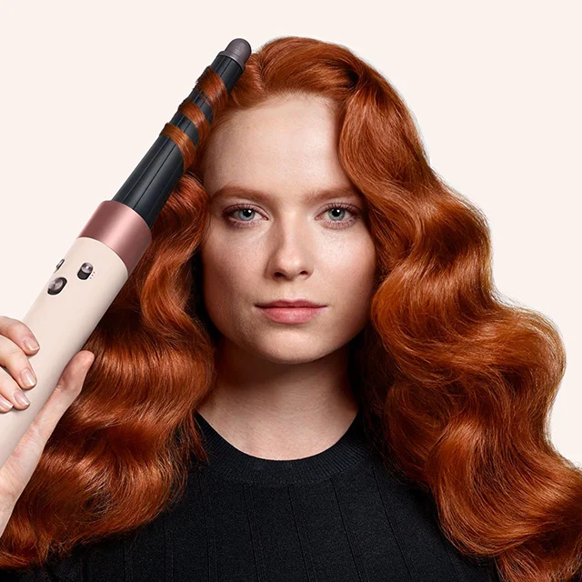 Model styles her hair with the Dyson Airwrap i.d. multi-styler and dryer in Ceramic pink and rose gold