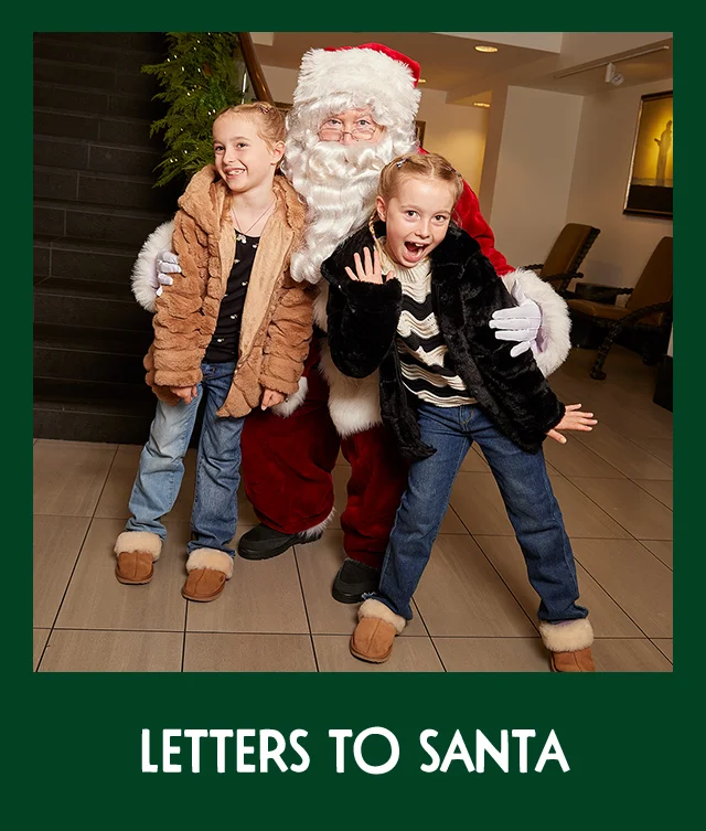 Two little girls posing with Santa at Nordstrom.