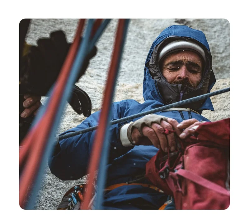 A climber looks into his pack during a big wall climb.
