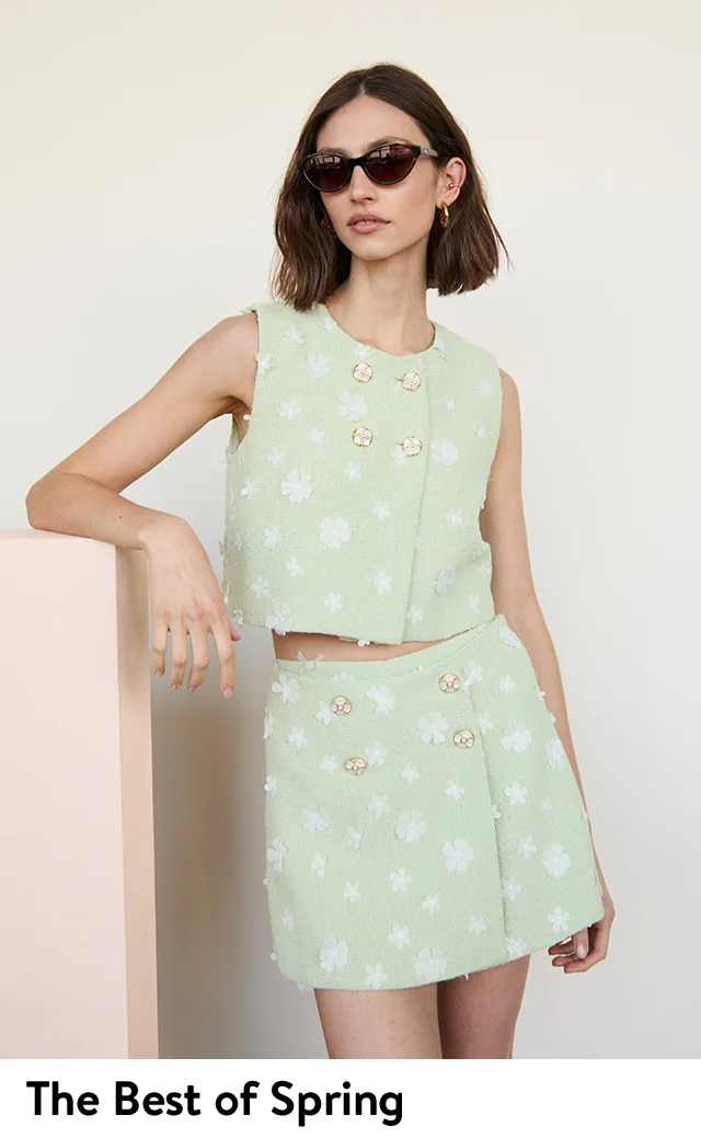 A woman wearing a pastel green embellished tank and matching miniskirt.