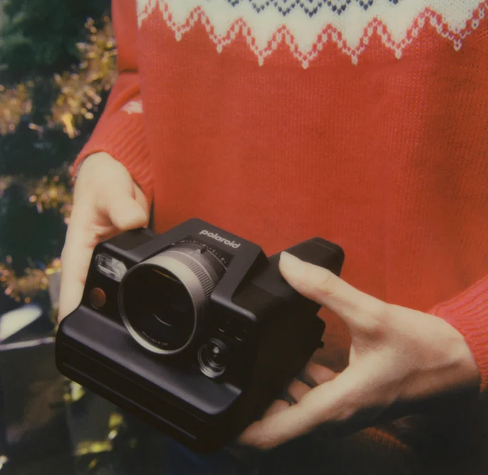 Hands holding a Polaroid I-2 camera