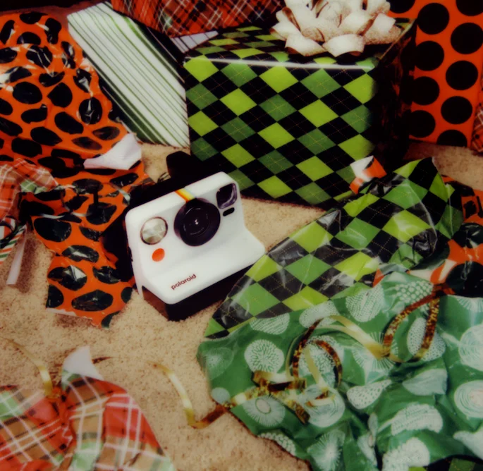 Polaroid Now Gen 2 surrounded by holiday ornaments