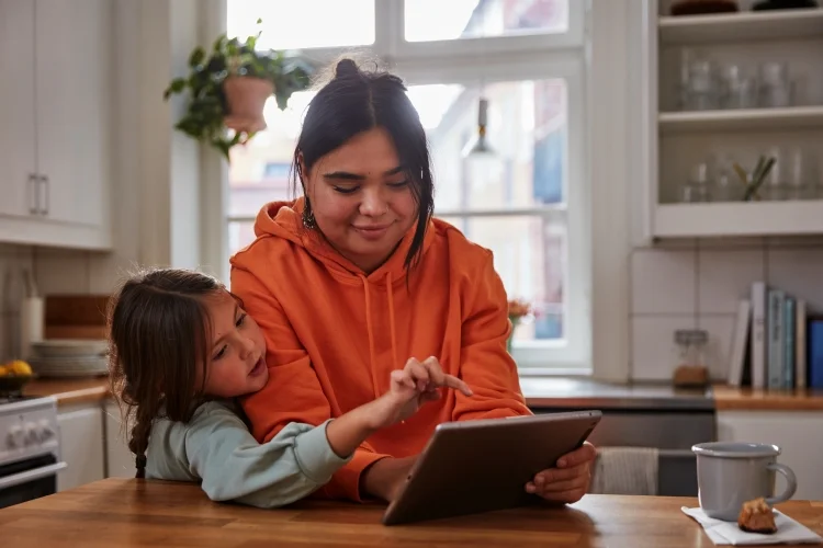 lady looking at computer with little girl