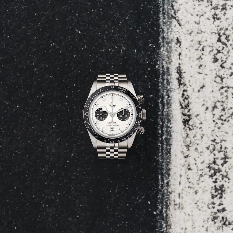 A sleek silver, black and white watch on a black and white background. A sleek silver, black and white watch on a black and white background.