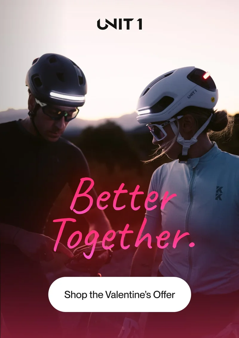 A couple wearing FARO and AURA helmets, enjoying a shared cycling moment at sunset.