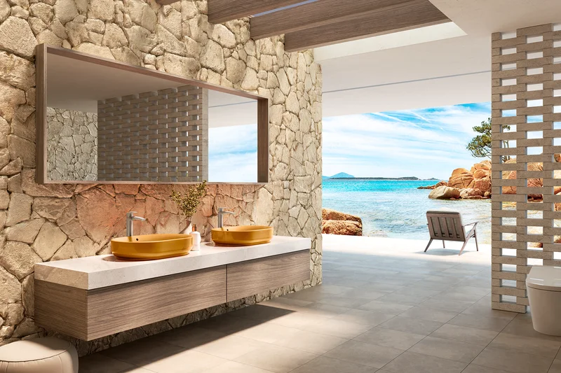 A beach front luxury bathroom with a large mirror and stone textured walls