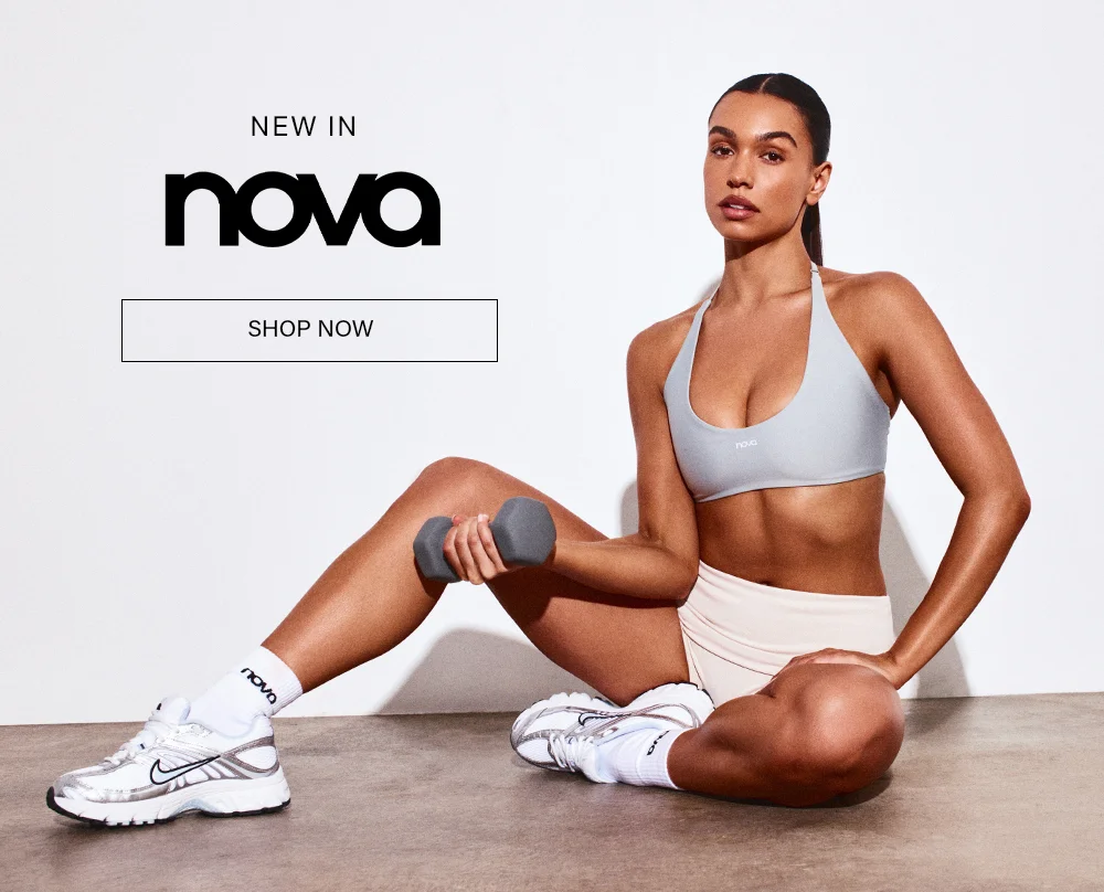 Nova NEW IN: Woman in grey sports bra, shorts, sneakers, holding dumbbell. Shop high-performance women's activewear.