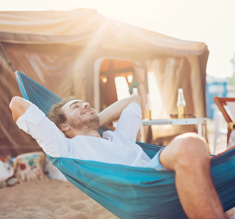 A man relaxing in a hammock on the beach
