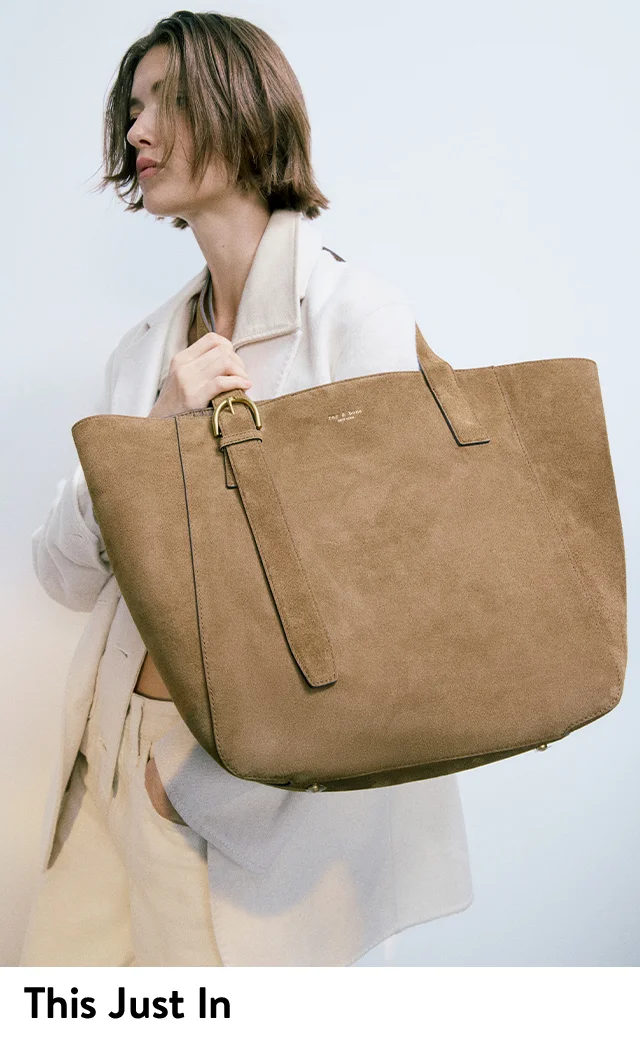 A woman holding a large brown tote.