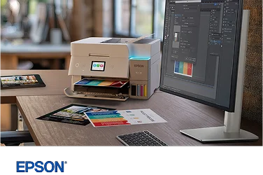 An Epson EcoTank color printer on a desk next to a Dell monitor and keyboard.