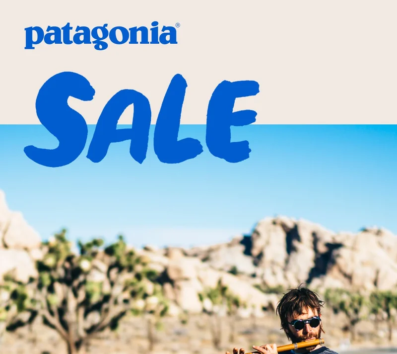 Patagonia Sale. A person playing a flute on the side of the road with climbing gear piled at their feet.