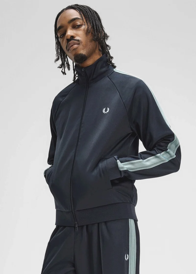 A male model wearing a Fred Perry Mesh Taped Track Jacket in Navy