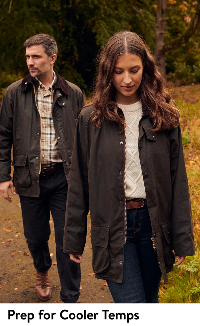 A man and woman wearing coats from Barbour.