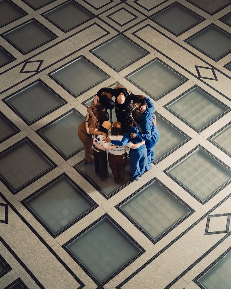 Group of seven people huddled