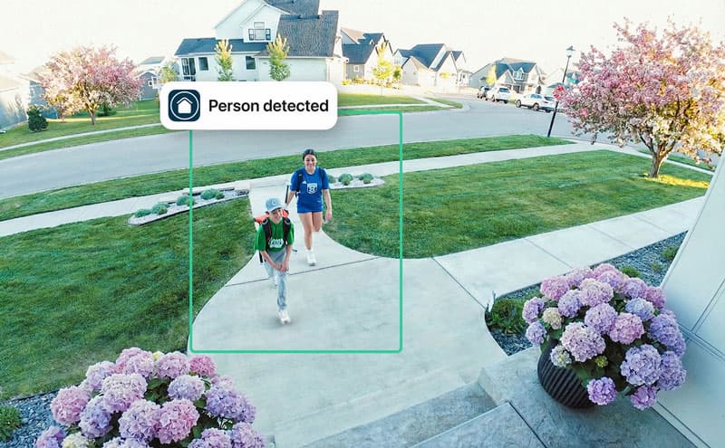 Simulated point of view image depicting a red car in front of a home with flowers in the front yard. A green box highlights the car to indicate an event with a simulated event caption that says: Dylan's Car recognized.