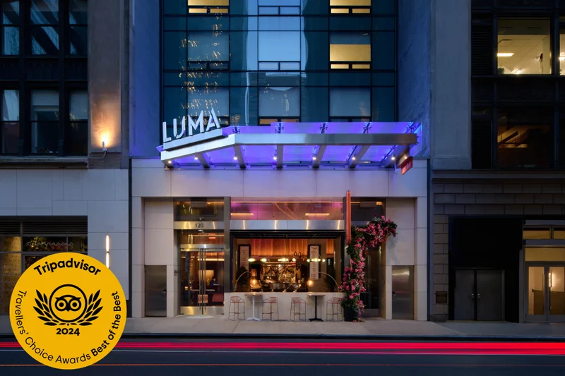 Exterior of LUMA Hotel Times Square at night, with TripAdvisor award seal