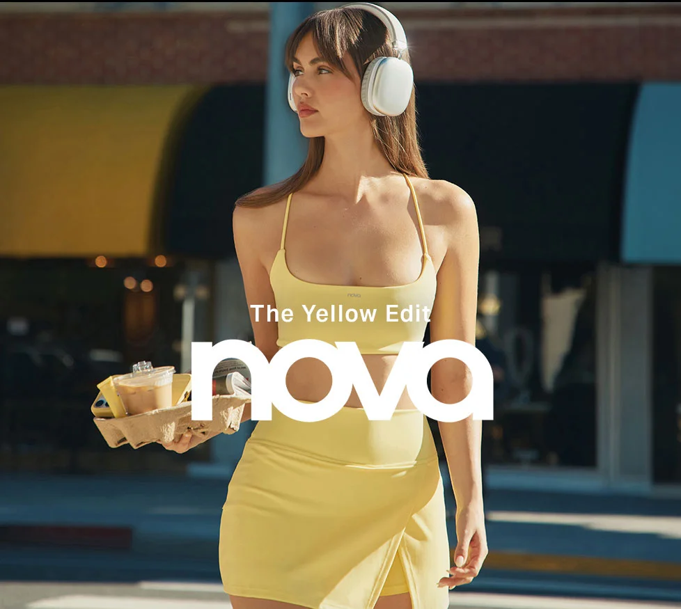 Young woman in a yellow activewear matching set with white headphones, holding iced coffees. Promoting Nova's Yellow Edit fashion collection.