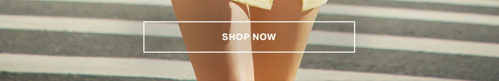 Sun-kissed legs wearing chic light yellow apparel on a striped floor. Shop our latest fashion collection and elevate your summer style now.