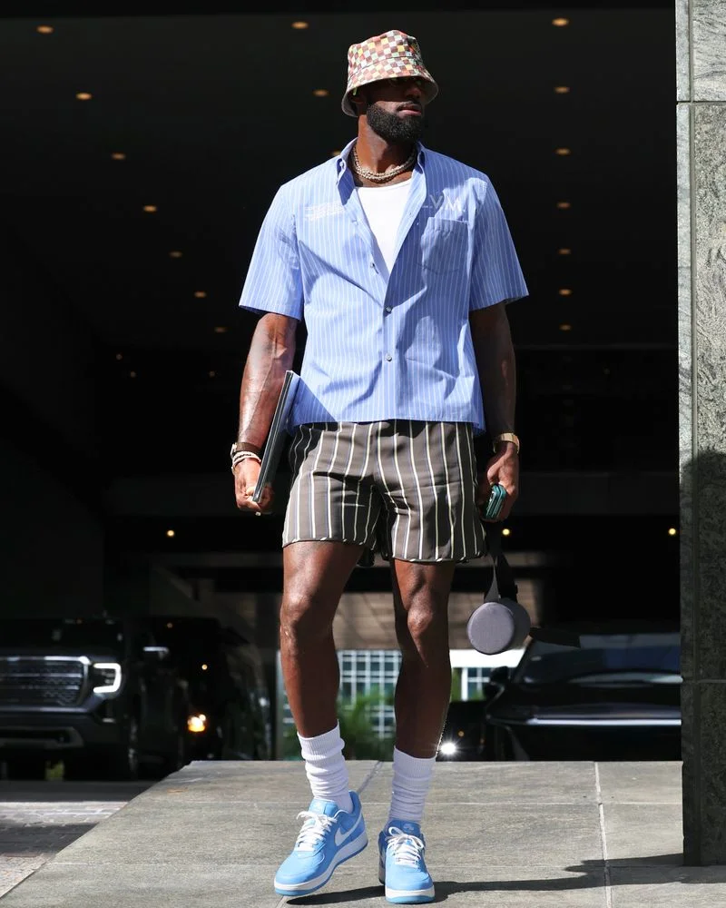 Image may contain: LeBron James, Clothing, Shorts, Adult, Person, Shirt, Standing, Gun, and Weapon