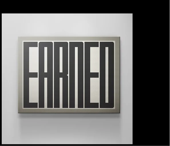 Framed canvas artwork featuring the word “EARNED” in bold, vertically elongated black typography on a beige background, mounted on a light grey wall. Framed canvas artwork featuring the word “EARNED” in bold, vertically elongated black typography on a beige background, mounted on a light grey wall.