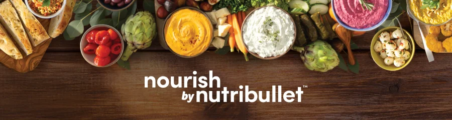 A table displays a variety of fresh foods including dips, vegetables and bread. The text reads 'nourish by nutribullet'.