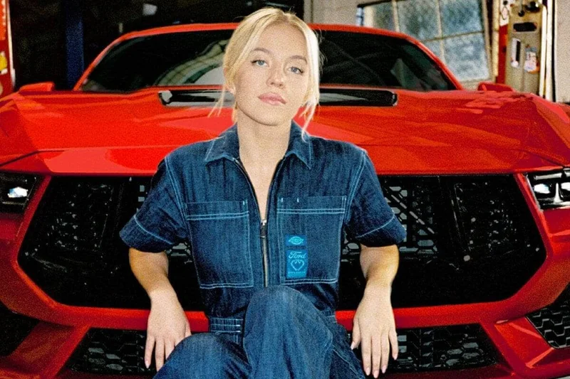 Sydney Sweeney leaning against a red 2024 Ford Mustang® coupe