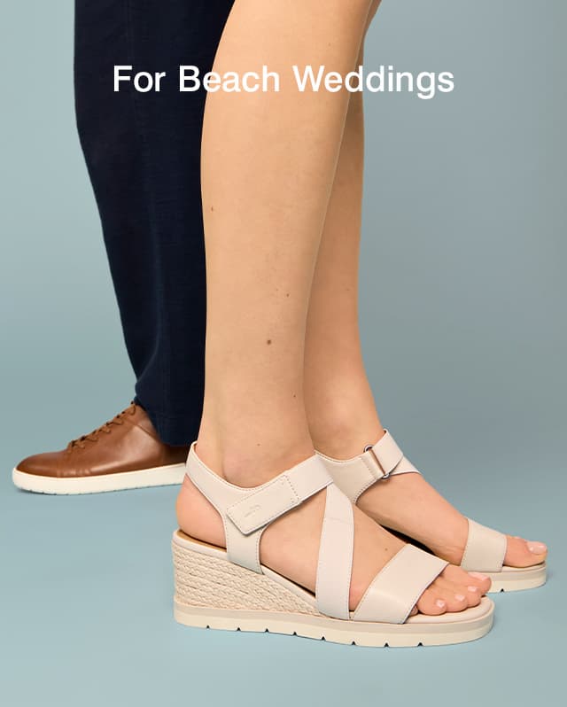 A woman wearing the Inca Espadrille Wedge in Stone standing front of a man in the Benji Wide-Width Sneaker in Tan.