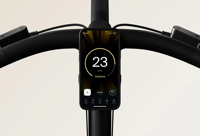 Close-up of the Cowboy bike’s handlebars with a smartphone mounted, displaying the Adaptive Power mode at 23 km/h.