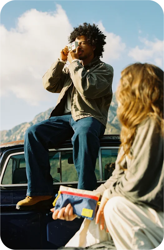 Two people on the bed of a truck taking a picture