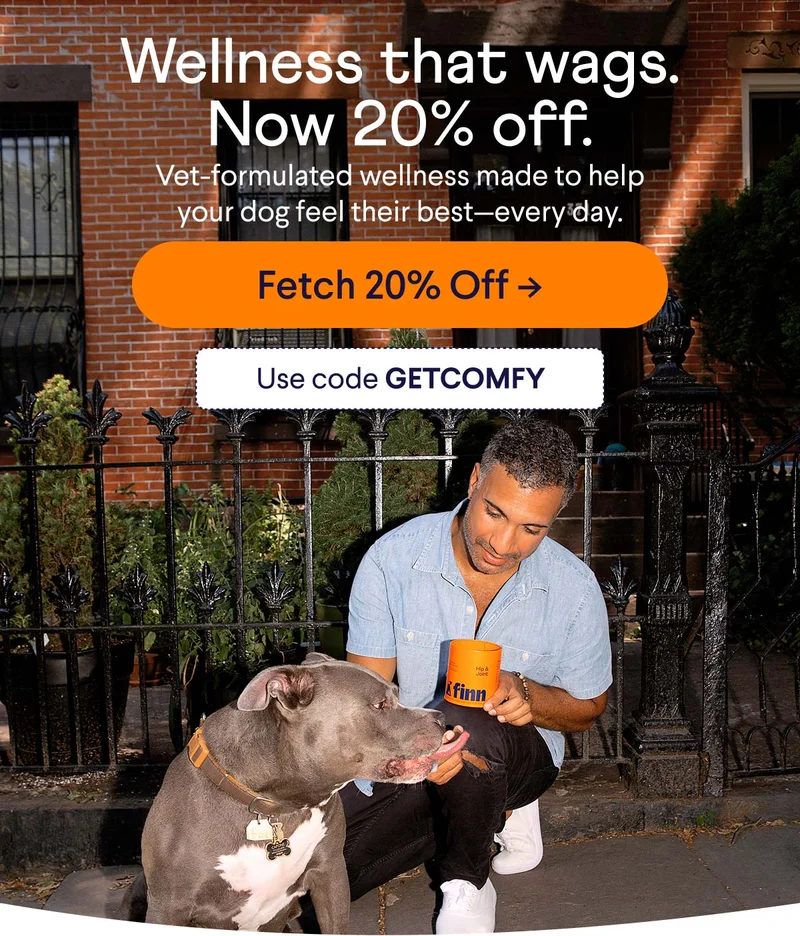 Photo of a man kneeling and feeding his dog a soft chew from a Hip & Joint tin outdoors in front of a brick building. Wellness that wags. Now 20% off. Vet-formulated wellness made to help your dog feel their best–every day. Button reads "Fetch 20% Off". Use code GETCOMFY.