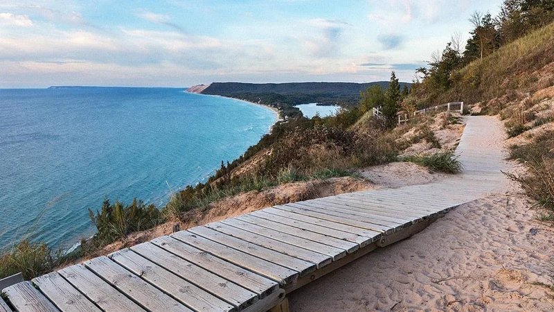 Image description: Boardwalk with view of lake and dunes at Sleeping Bear Dunes in Michigan