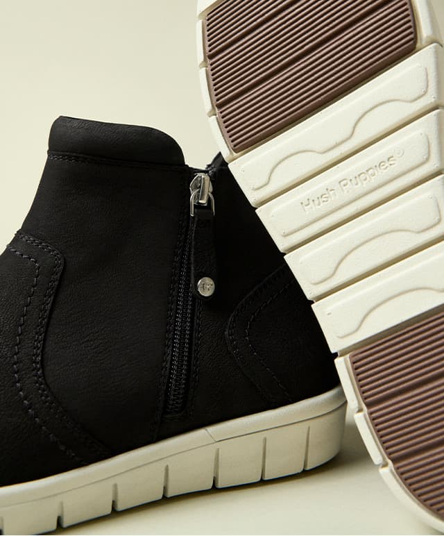 Another image of the leather ankle bootie revealing the zipper on one shoe and the sole on the other. Shop Now.