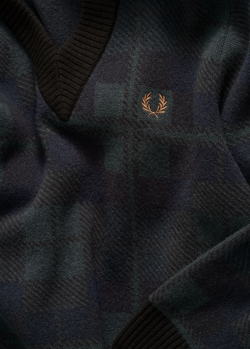 The Black Watch Tartan edit: photo is a detailed close-up of the black tartan pattern on a knitted v-neck jumper