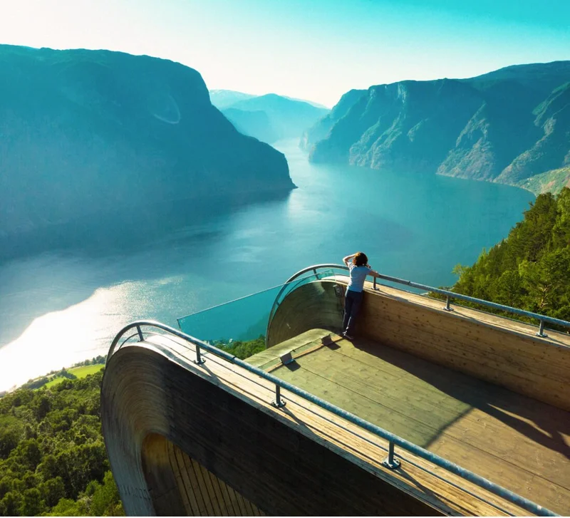 Image Description: A traveler standing on the Stegastein viewing platform that overlooks the Aurlandsfjord in Norway