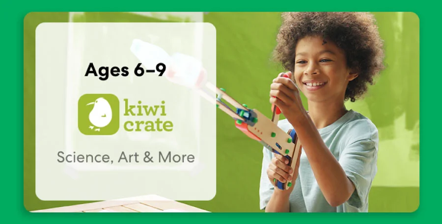 Young child smiling while working on a science experiment from KiwiCo Labs. Hands-on STEM learning for ages 6–9