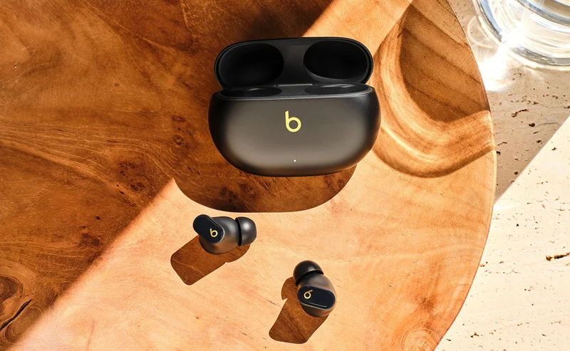 Beats Studio Buds + earbuds and case sitting on a wooden table