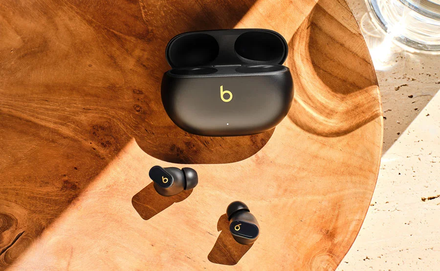Beats Studio Buds + earbuds and case sitting on a wooden table