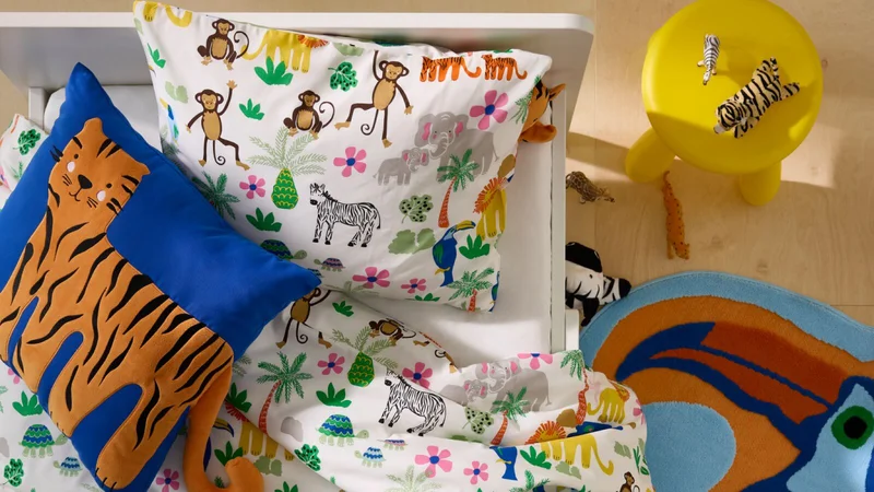 A bed dressed in NATTHÄGER bedding, with illustrations of different jungle plants and animals.