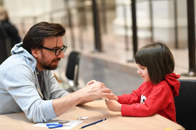 A photograph of a father and child making art