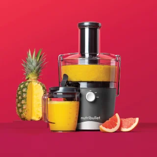 nutribullet juicer with sliced pineapple and orange slices.