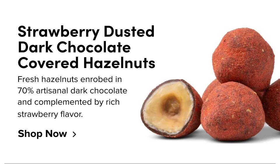 Strawberry Dusted Dark Chocolate Covered Hazelnuts; Fresh hazelnuts enrobed in 70% artisanal dark chocolate and complemented by rich strawberry flavor. Shop Now