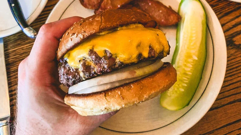 Image description: Person holding a burger at Red Hook Tavern.