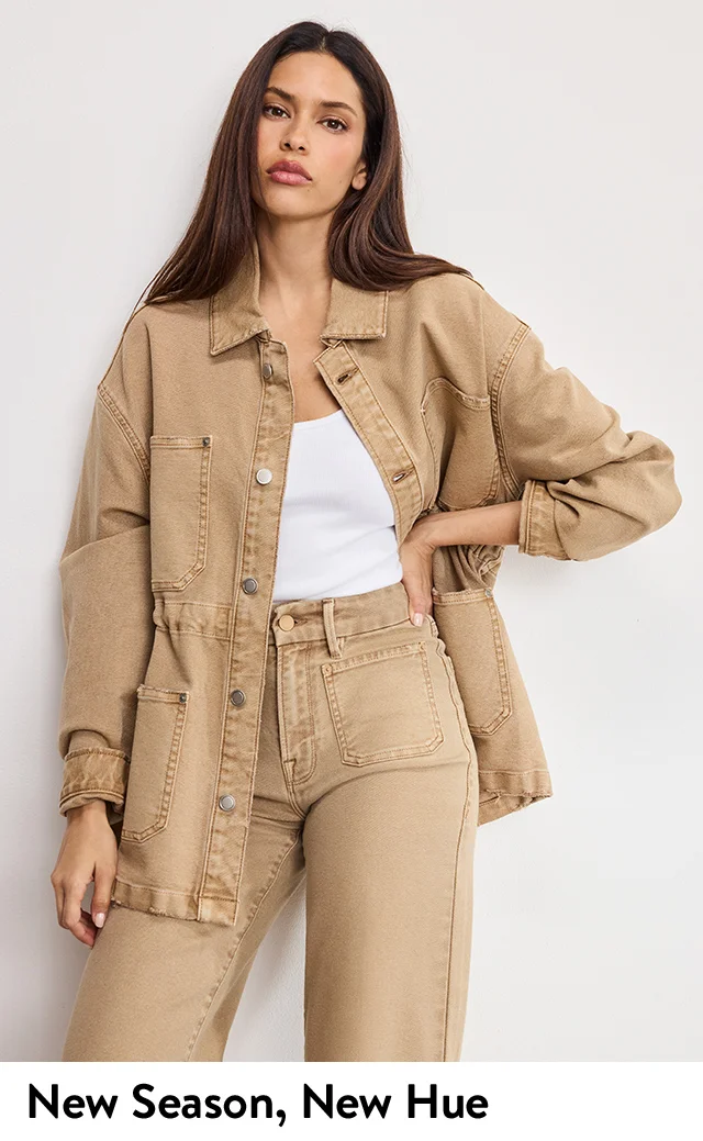 A woman wearing a light-brown denim jacket with matching jeans.