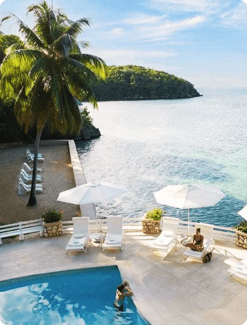 Image Description: Aerial shot of an oceanside pool deck in Couples Sans Souci, an all-inclusive resort in Jamaica