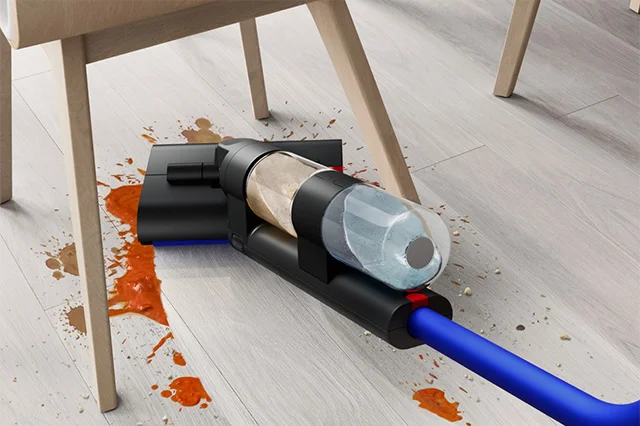A close-up of the Dyson WashG1 reaching low to reach food spills under a kitchen table