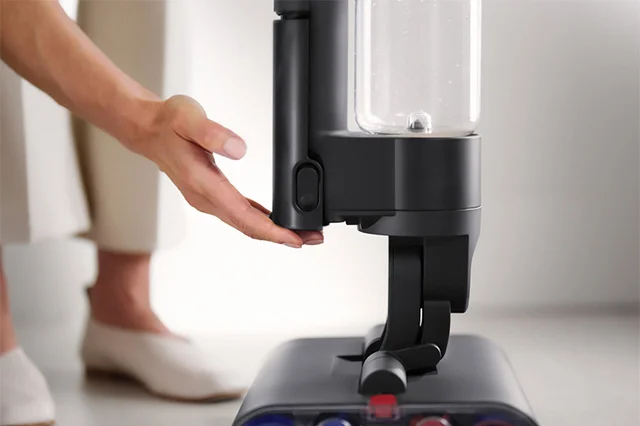 Woman touching the Dyson WashG1 wet cleaner's battery pack